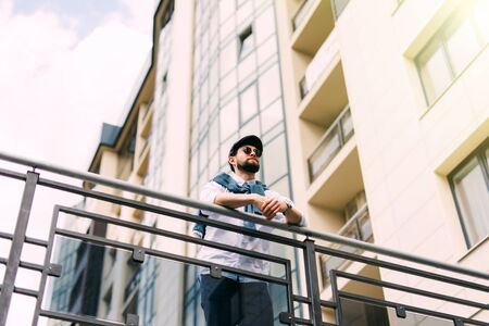 Handsome man walking in the street, checking his phone and drinking coffeeの写真素材