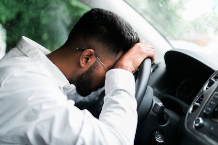Drunk man slumped on steering wheel in his carの写真素材