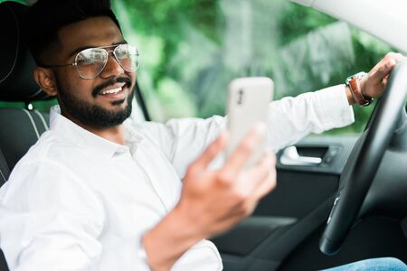 Man sitting on backseat taxi car and hand holding smartphone to use online application.