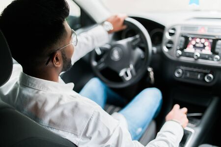 Rear view of young handsome man looking straight while driving a carの写真素材
