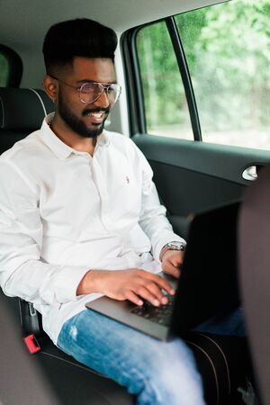 Full concentration at work. Confident young man in full suit working using laptop while sitting in...