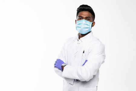 Handsome Indian Male Doctor with surgical or safety health Mask on. standing isolated over blue backgroundの写真素材