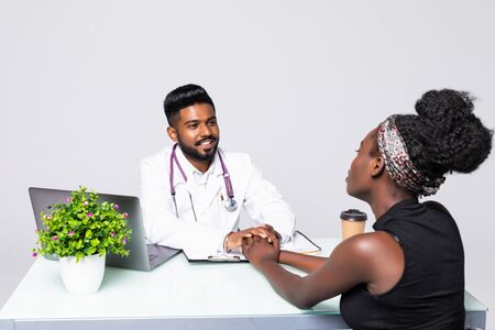 Male doctor and patient in discussion at desk in medical officeの写真素材