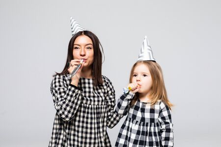 Little girl and mother having fun celebrate isolated on white background.