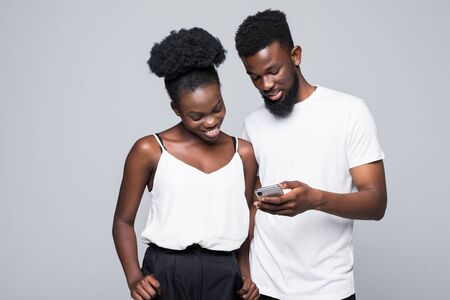 Pretty couple hugging and using smartphone isolatedの写真素材