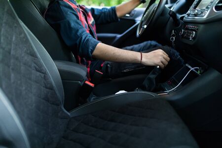 a man in a business suit in the car changes gear