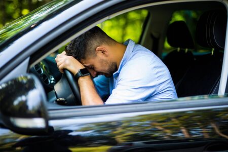 View of tired businessman driving a carの写真素材