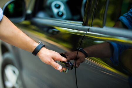 Man opening a car door in a garageの写真素材
