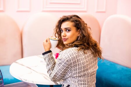 Young woman in a cafe drinking coffee