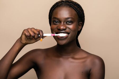 Close up of a young african american woman brushing her teeth with a toothbrush