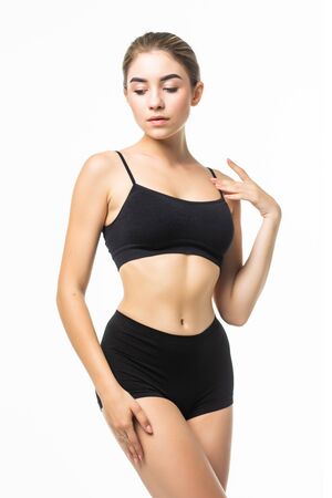 Slim slender woman in black underwear posing against white background. Wellness and body care concept.の写真素材