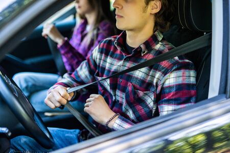 Responsible people placing safety as their priority by putting the seatbelt on before drivingの写真素材