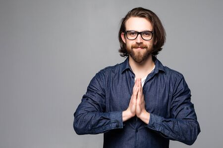 Praying young businessman isolated over white backgroundの写真素材