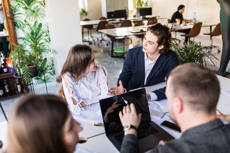 Group of business partners discussing ideas and planning work in office