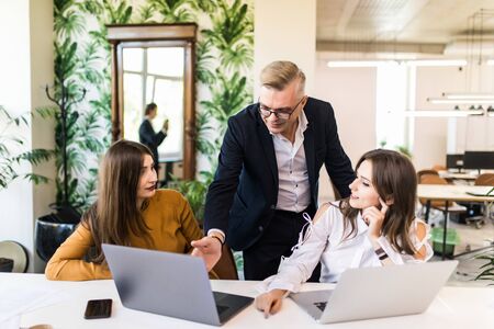 Happy business team using laptop in meeting at office