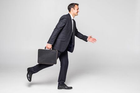 Businessman running with a briefcase over white backgroundの写真素材