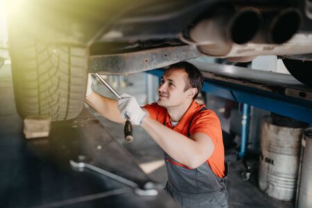 Auto car repair service center. Mechanic examining car