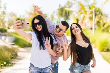 Three young women having fun and taking selfie. Group of friends enjoying a day outdoors.