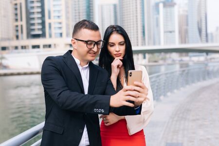young businesswoman and businessman with mobilephon planing a work on outdoor.の写真素材