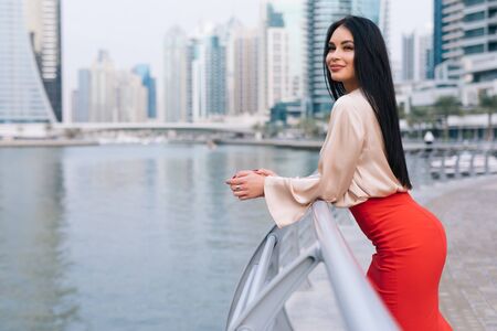 Elegant businesswoman possing in the city outdoors on rest skyscrapers background.の写真素材