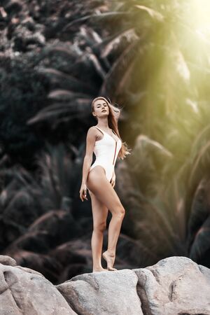 Beautiful and sexy woman on the beach with rocksの写真素材