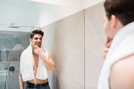 Attractive man drying his face in the mirrorの写真素材