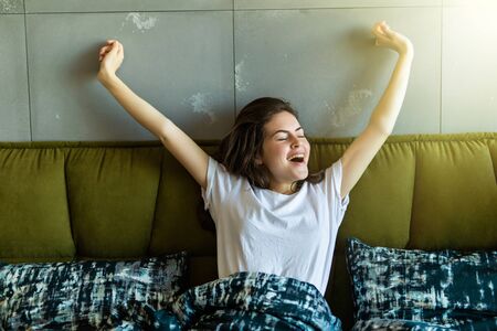 pretty happy girl waking up in the morning and stretchingの写真素材