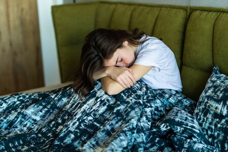 Young caucasian female on bed. Insomnia or depression concept