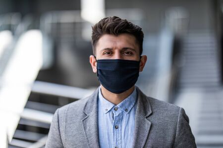 Young businessman in office wearing surgical hygienic protective mask on face. Idea for prevent crisis of coronavirus and health care for safe of worker and employee.の写真素材