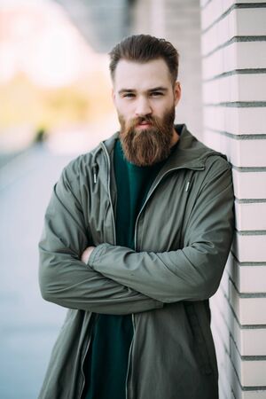 Stylish young bearded guy in casual clothes outdoorsの写真素材