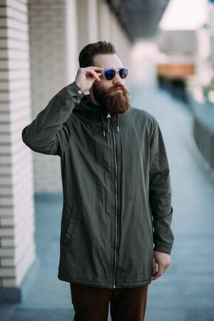 Young bearded man in sunglasses on the street walk in the city.の写真素材
