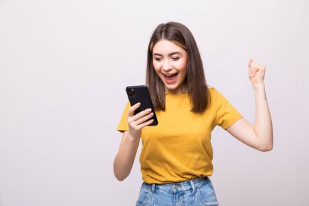 Successful happy woman holding mobile phone on a white backgroundの写真素材