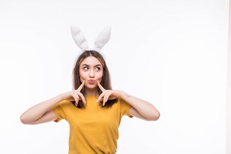 beautiful young woman wearing cute bunny ears and holding her head in her palmsの写真素材