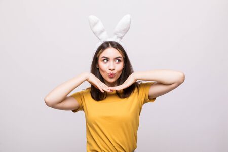 beautiful young woman wearing cute bunny ears and holding her head in her palmsの写真素材