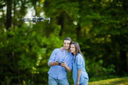Young couple navigating a flying drone with remote control.の写真素材