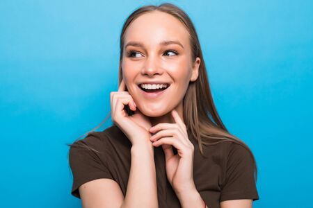 beautiful cheerful teen girl in white top over blue backgroundの写真素材