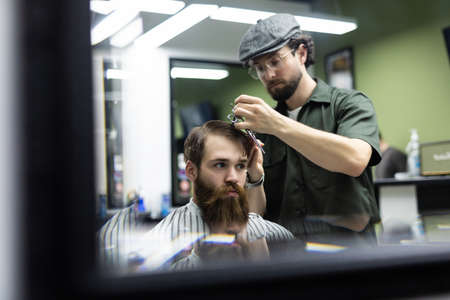 Haircut men Barbershop. Men's Hairdresser barbers. Barber cuts the client machine for haircuts.