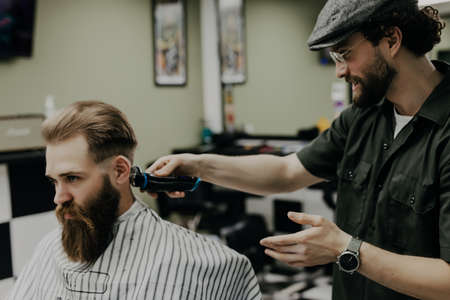 Haircut men Barbershop. Men's Hairdresser barbers. Barber cuts the client machine for haircuts.