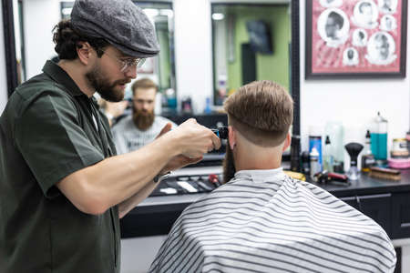 Haircut men Barbershop. Men's Hairdresser barbers. Barber cuts the client machine for haircuts.