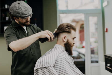 Haircut men Barbershop. Men's Hairdresser barbers. Barber cuts the client machine for haircuts.