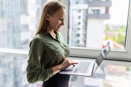 Businesswoman working at office desk and texting with her mobile phone