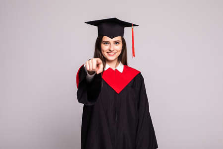 Female graduate student pointing with fingers on you on white backgroundの写真素材