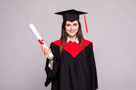 Educational theme: graduating student girl in an academic gown. Isolated over white background.の写真素材