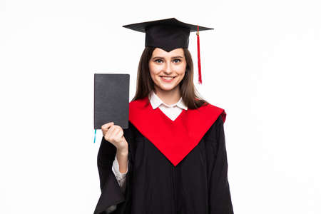 College degree. Happy young women in mortarboard holding diploma and smiling at camera while isolated on whiteの写真素材
