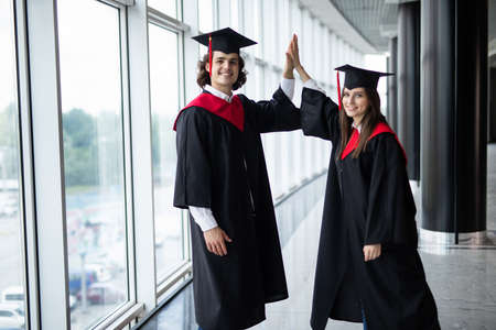 A man and woman couple at college graduation give give in Universityの写真素材