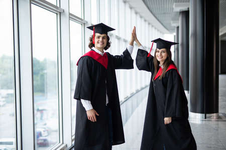 A man and woman couple at college graduation give give in Universityの写真素材