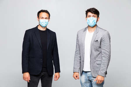 Two young man in medical mask in suits at a meeting on a white backgroundの写真素材