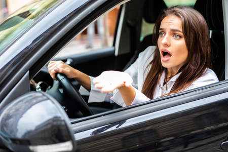Beautiful angry woman honking in her car while drivingの写真素材