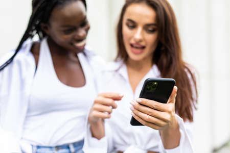 Two Beautiful Women Sending Messages with Mobileの写真素材