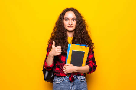 Teenager student girl over yellow background giving a thumbs up gesture